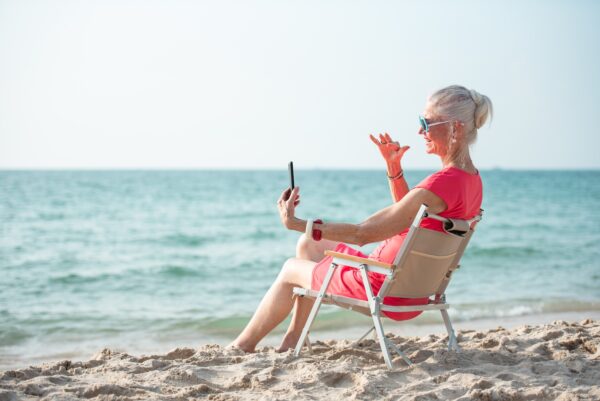 op strand met een telefoon